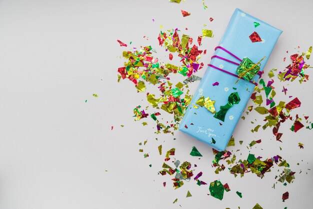 Confetti over the wrapped gift box against white background