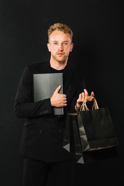 Confident adult male with shopping bags