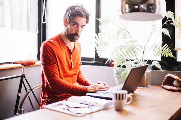 Confident adult man posing at table