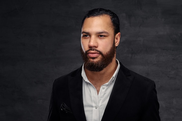 Free photo confident african-american businessman in a black classic jacket. isolated on a dark background.