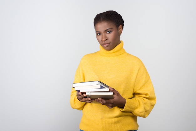 Confident African American student holding books