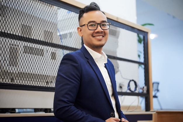 Free photo confident asian businessman in suit posing in office