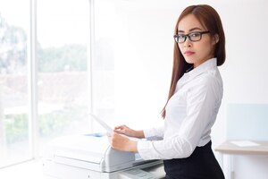 Бесплатное фото Уверенный женщина азии использование photocopier в офисе