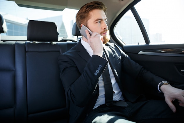 Confident bearded businessman talking on mobile phone