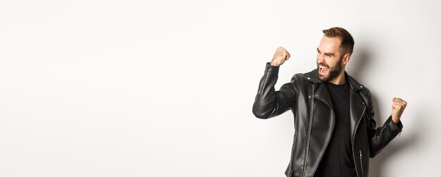 Confident bearded man celebrating victory winning prize making fist pump and rejoicing wearing black