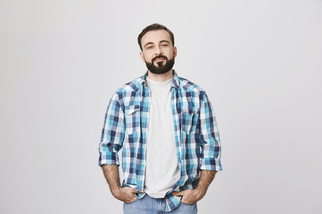 Confident bearded man in plaid shirt smiling
