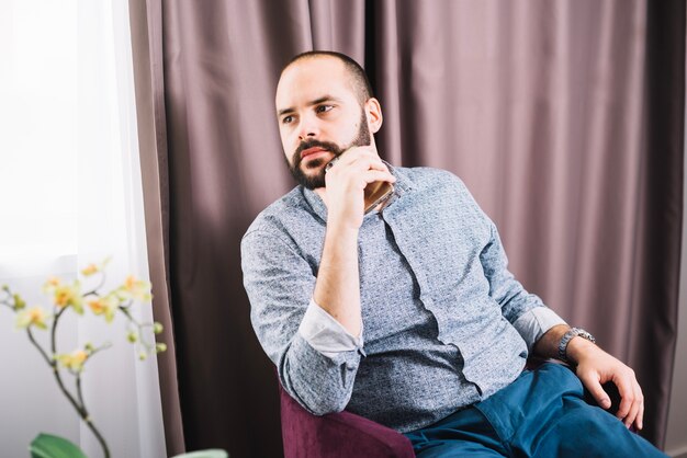 Confident bearded man posing in chair