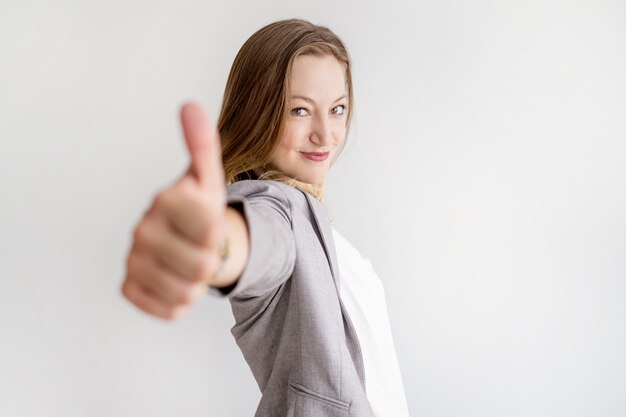 Confident beautiful business woman showing thumb up