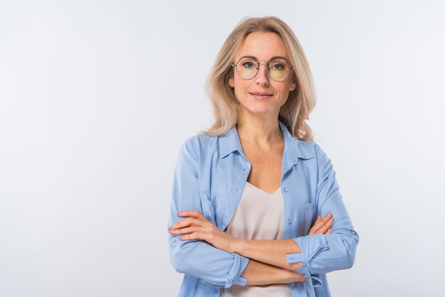 confident blonde young woman with crossed arms standing against white background