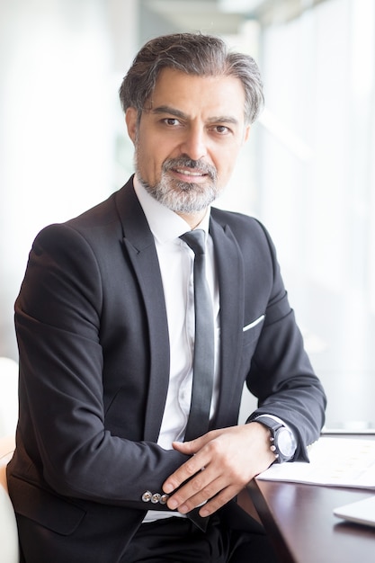 Confident Business Leader Sitting at Table