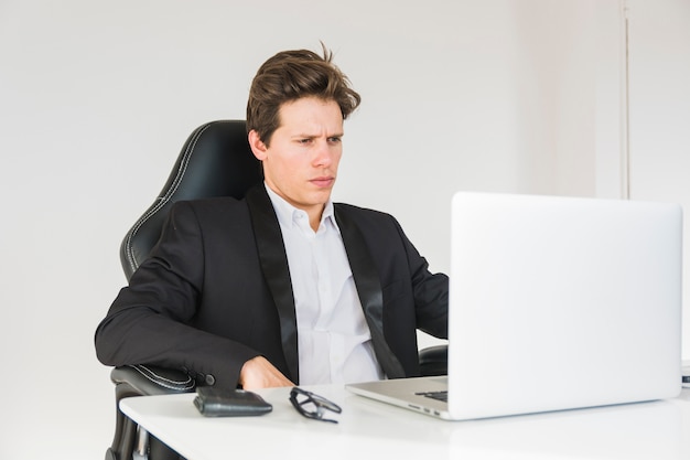 Confident businessman looking at laptop