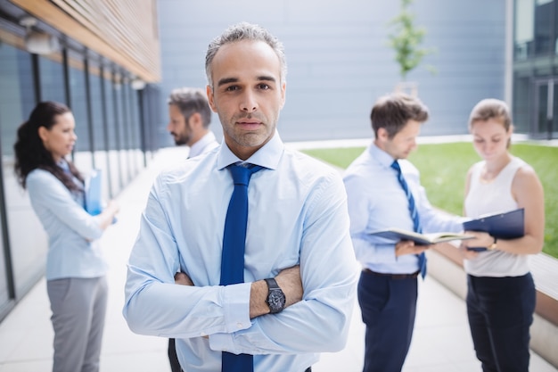 Confident businessman standing outside office building