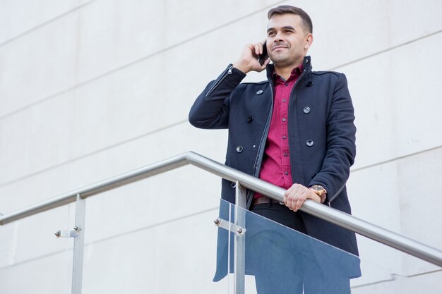 Confident businessman talking on mobile phone