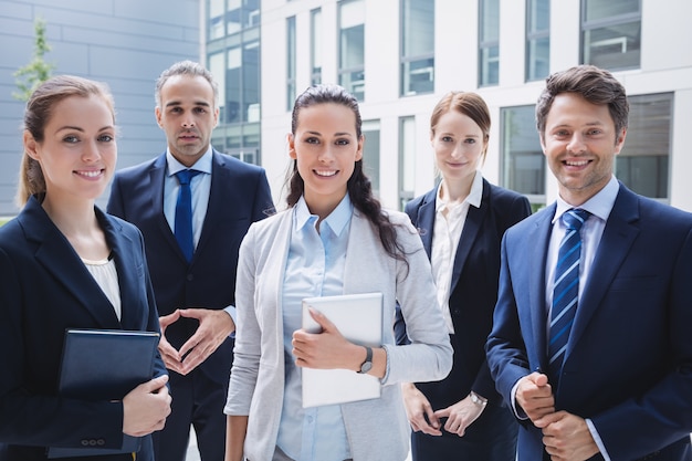 Confident businesspeople standing outside office building