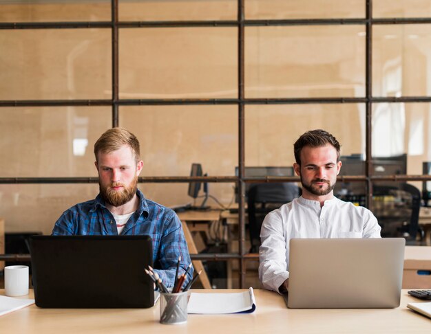 Confident businesspeople working on computer in office