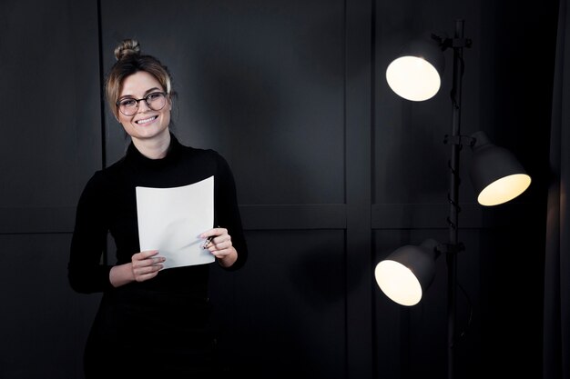 Confident businesswoman holding papers at the office