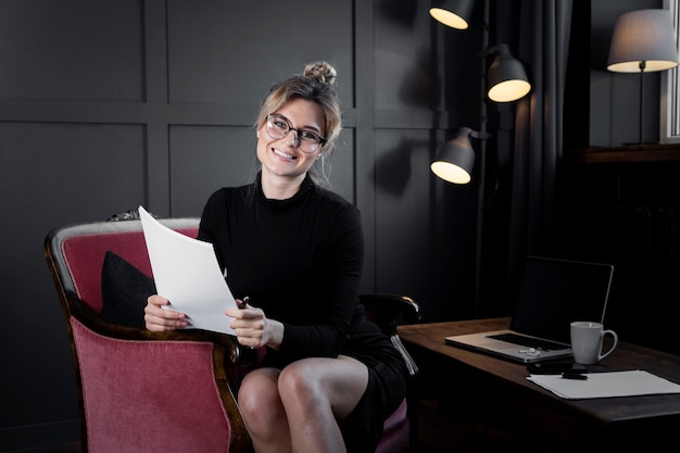 Confident businesswoman holding papers