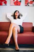 Free photo confident businesswoman posing on sofa