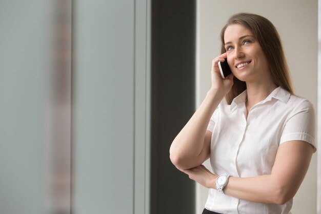 自信を持って女性実業家の携帯電話で話している