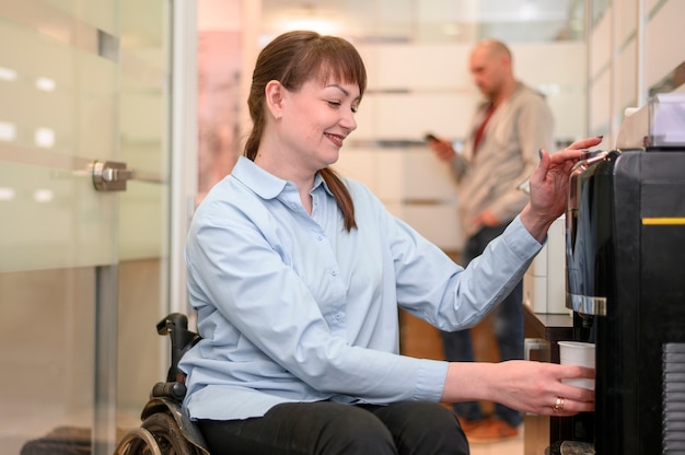 Confident businesswoman in wheelchair pouring water