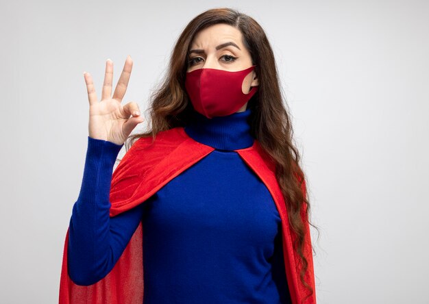 赤い保護マスクを身に着けている赤いマントと自信を持って白人のスーパーヒーローの女の子
