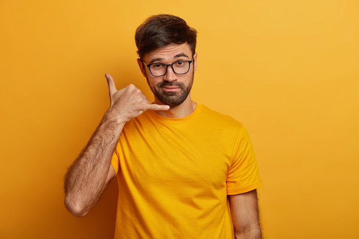 Free Photo confident charismatic man makes call me gesture, communicates with gestures