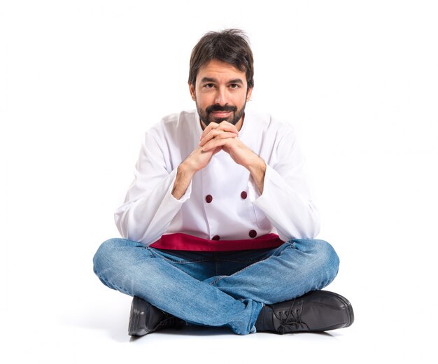 Confident chef sitting on the floor