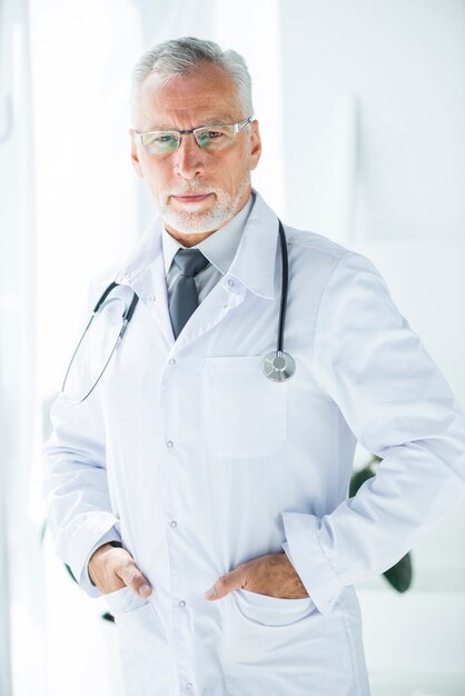 Confident doctor keeping hands in pockets