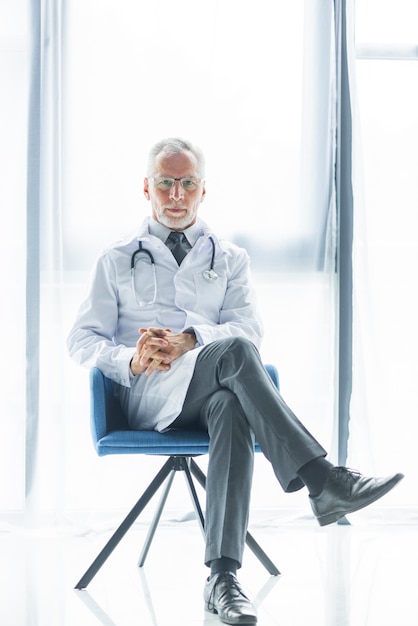 Free photo confident doctor sitting on chair