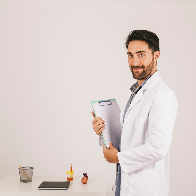 Confident doctor with clipboard