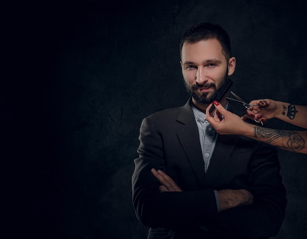 Confident elegant businessman receive a beard care from female with nice manicure.