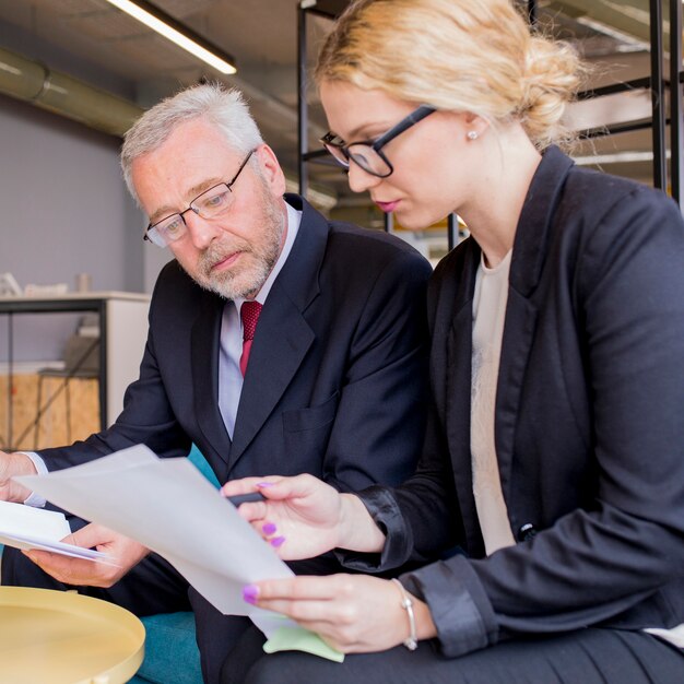 Confident employees discussing papers at meeting