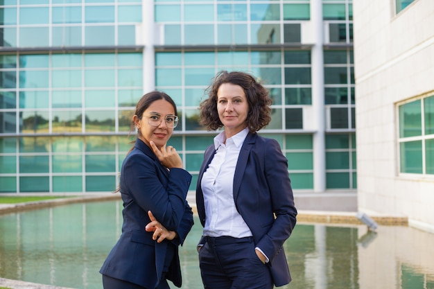 Confident female business professionals posing outside