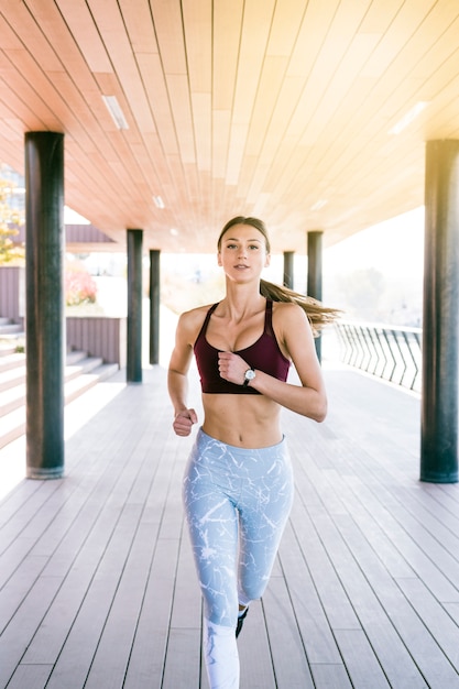 Foto gratuita giovane donna sicura di forma fisica che corre di mattina