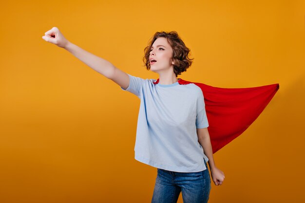 Confident girl in red mantle having fun during photoshoot 