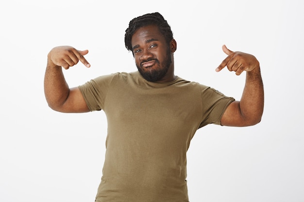 Free photo confident guy in a brown t-shirt posing against the white wall