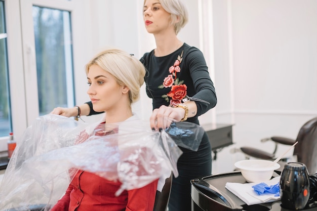 Confident hairstylist working with customer