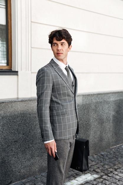 Confident handsome businessman in suit holding car keys