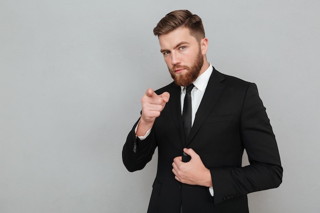 Confident handsome businessman in suit pointing finger