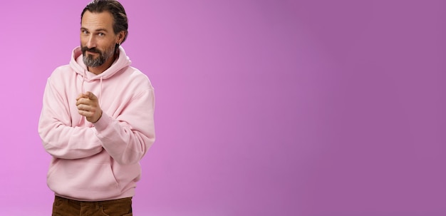 Free photo confident handsome charismatic adult bearded man in stylish pink hoodie inviting you join company sm