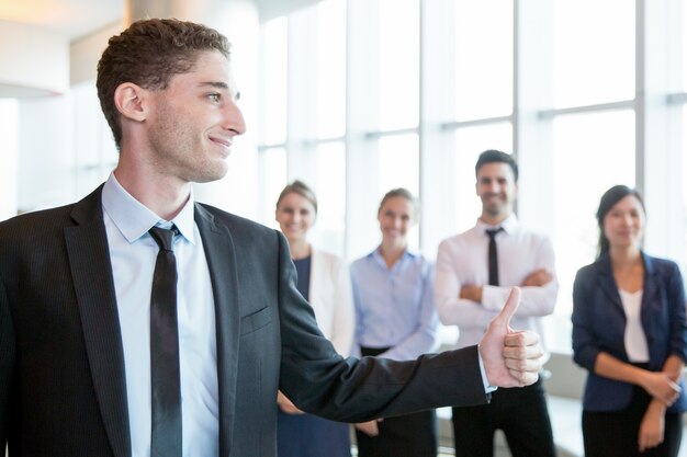 Confident handsome employer showing thumb-up