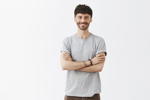 Confident handsome guy posing against the white wall