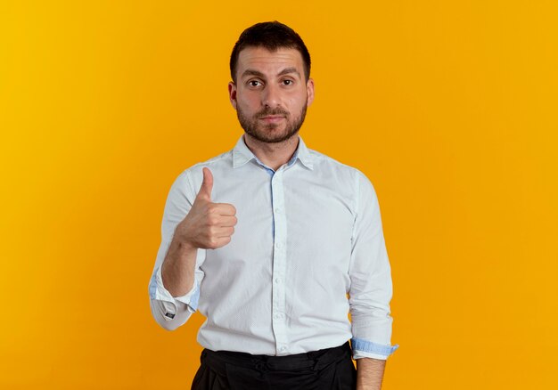 Confident handsome man thumbs up isolated on orange wall