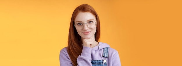 Бесплатное фото Уверенная счастливая расслабленная европейская рыжеволосая умелая молодая женщина-предприниматель в очках устанавливает startu