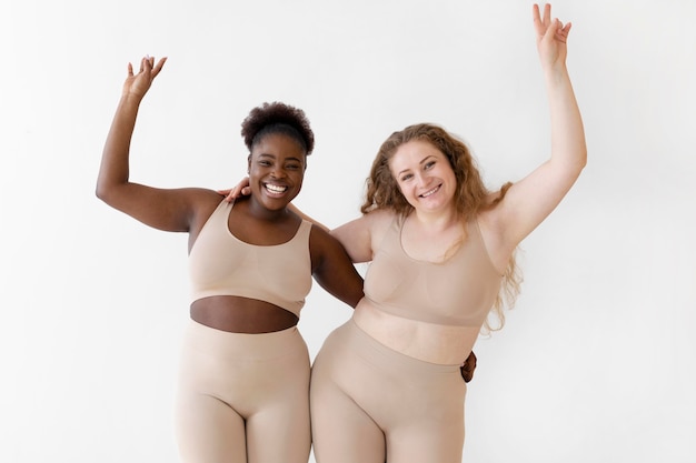 Free photo confident happy women posing while wearing a body shaper