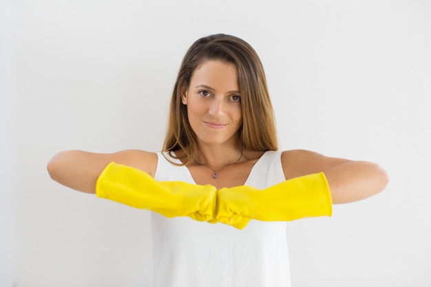 Free photo confident housewife in rubber gloves touching fists