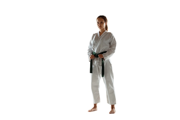 Уверенный в себе юниор в кимоно, практикующий рукопашный бой