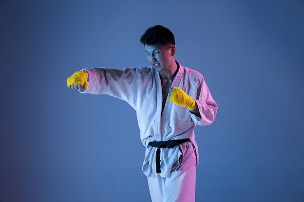 Confident korean man in kimono practicing handtohand combat martial arts