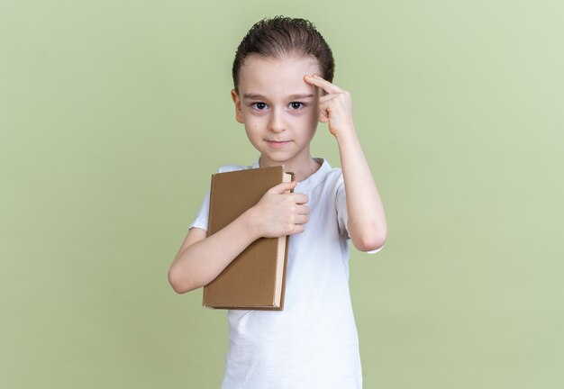 Confident little boy holding book doing think gesture 