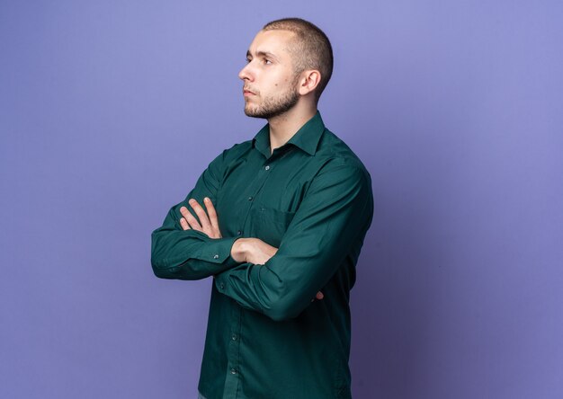 Confident looking side young handsome guy wearing green shirt crossing hands 